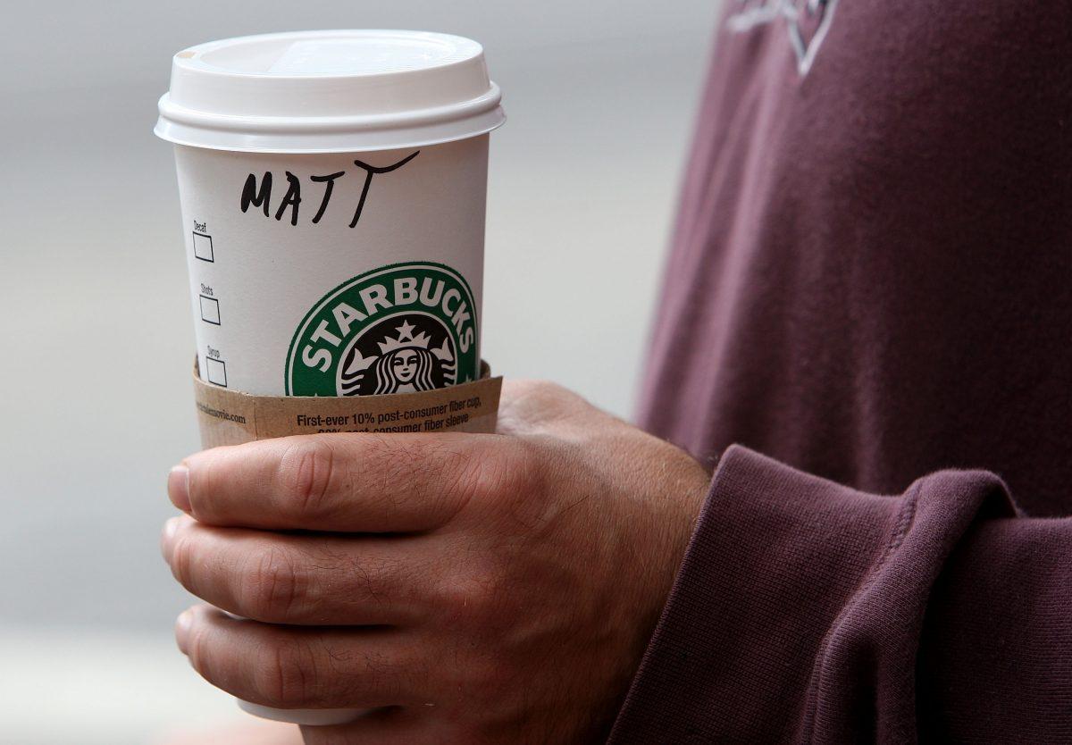 A Starbucks customer holds a coffee drink as he leaves a Starbucks store on July 31, 2007, in San Francisco. (Justin Sullivan/Getty Images)