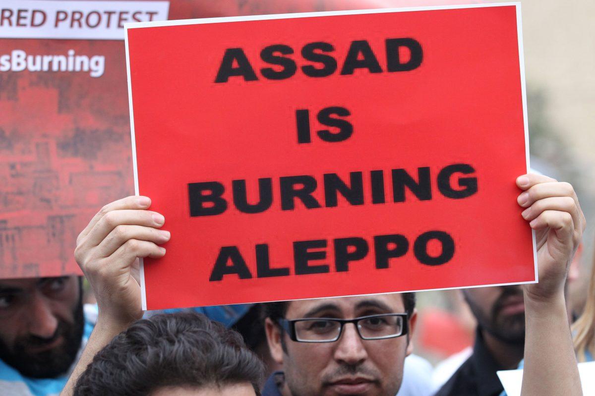 A protester holds a banner as he takes part in a demonstration in front of U.N. offices in Beirut in solidarity with the civilians of the northern Syrian city of Aleppo and against the regime of the Syrian President Bashar Assad, on May 1, 2016. (Anwar Amro/AFP/Getty Images)