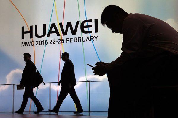 A man uses a mobile phone next to the stand of Chinese telecoms firm Huawei at the Mobile World Congress in Barcelona, Spain, on Feb. 22, 2016. (Lluis Gene/AFP/Getty Images)