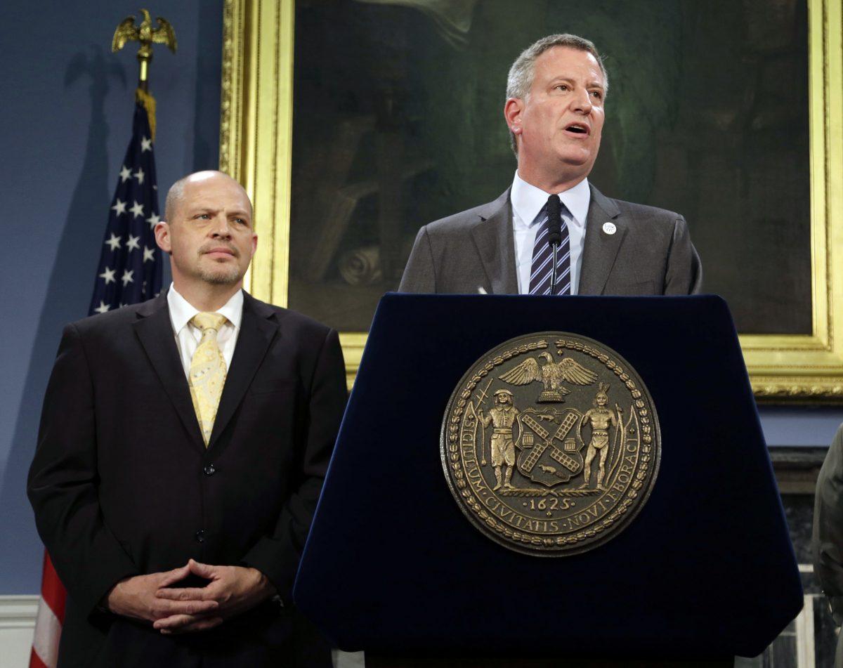 Michael Mulgrew (L), president of the United Federation of Teachers, listens as New York City Mayor Bill de Blasio speaks during a news conference at City Hall in New York, on May 1, 2014. (Seth Wenig/AP Photo)