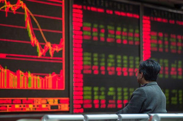 An investor watches stock prices on screens at a securities company in Beijing on March 22, 2016. (Fred Dufour/AFP/Getty Images)