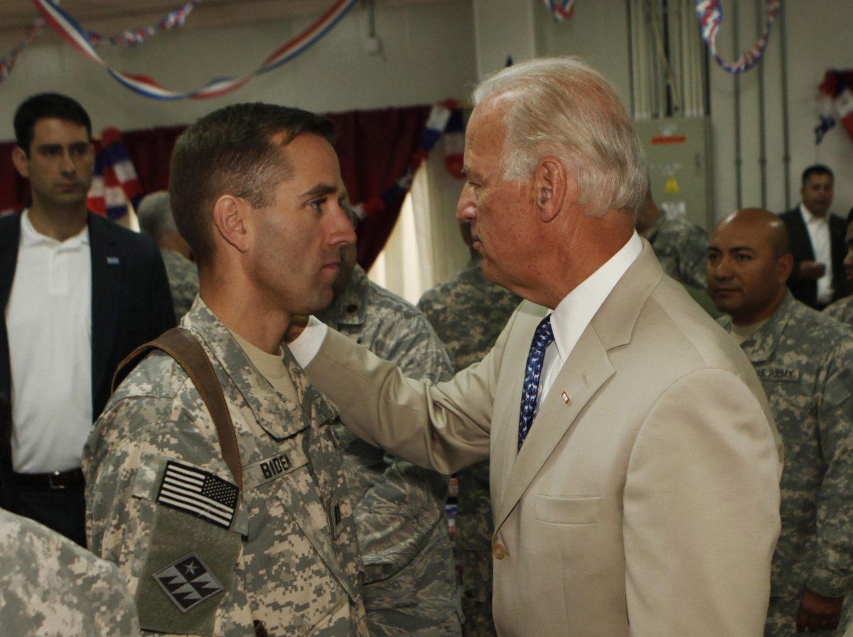 Then-U.S. Vice President Joe Biden talks with his son, U.S. Army Capt. Beau Biden (L), at Camp Victory on the outskirts of Baghdad on July 4, 2009. (Khalid Mohammed/AFP/Getty Images)