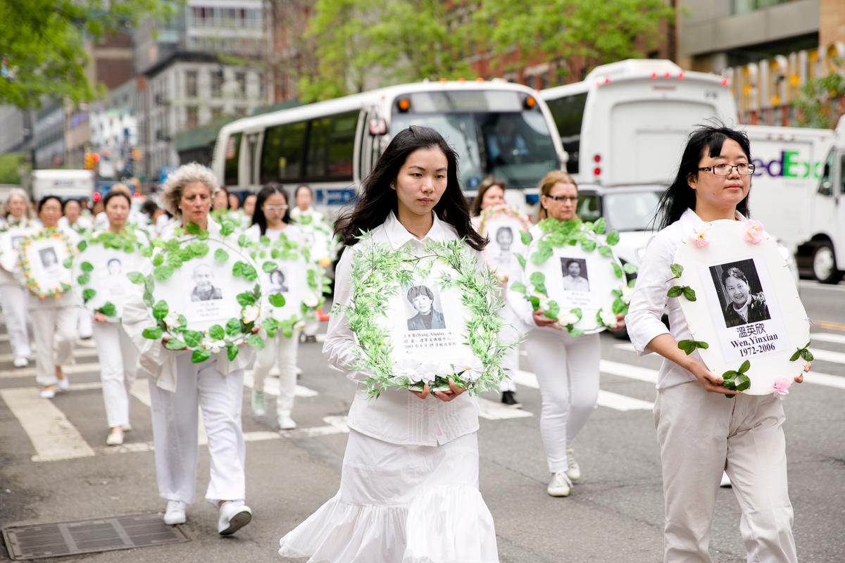 Falun Gong practitioners hold portraits of those killed in the persecution in China during the World Falun Dafa Day parade along 42nd Street in New York, on May 13, 2016. (Samira Bouaou/Epoch Times)
