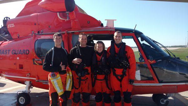 Team poses in front of helicopter after a search-and-rescue case May 16, 2016. (U.S. Coast Guard photo by Air Station Detroit)