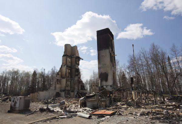A burned building stands among charred rubble in the neighborhood of Abasand in wildfire-ravaged Fort McMurray, Alberta, on Friday, May 13, 2016. (Jason Franson /The Canadian Press via AP)