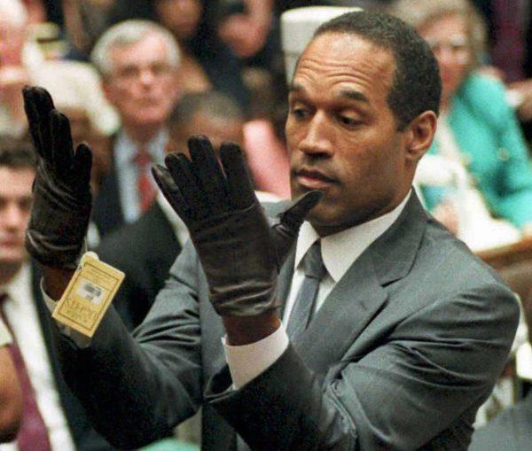 This 21 June 1995 file photo shows former US football player and actor O.J. Simpson looking at a new pair of Aris extra-large gloves that prosecutors had him put on during his double-murder trial in Los Angeles. (Vince Bucci/AFP/Getty Images)