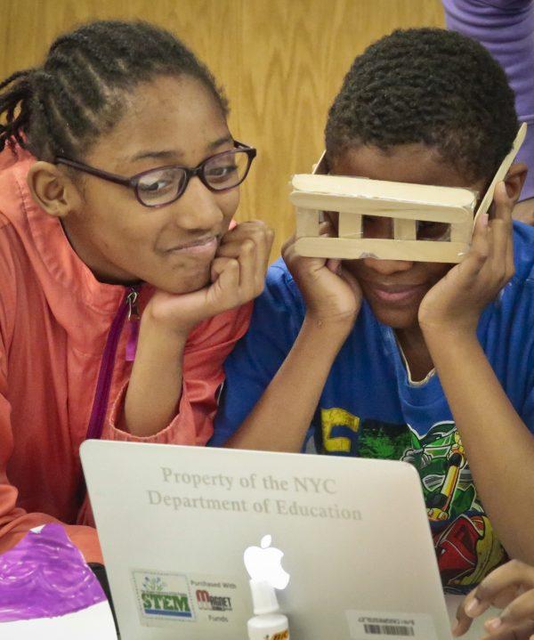 Fifth graders Azariah Drungo (L) and Noah Calendar, review a prototype eyeglass for a group entrepreneurial project developed in a mentorship program at Brooklyn's P.S. 307 in New York, on Thursday, May 19, 2016. (AP Photo/Bebeto Matthews)