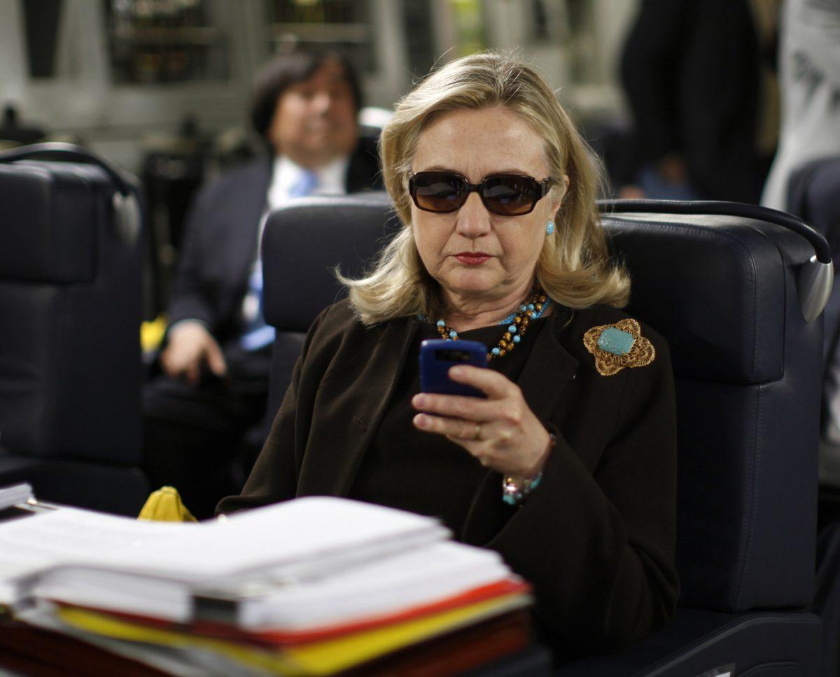 Hillary Clinton checks her Blackberry from a desk inside a C-17 military plane upon her departure from Malta, in the Mediterranean Sea, bound for Tripoli, Libya. (AP Photo/Kevin Lamarque, Pool)