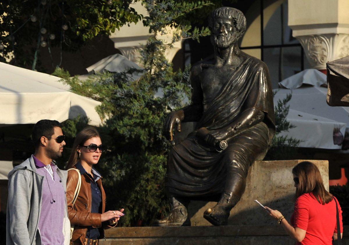People walk past a statue of ancient Greek philosopher Aristotle, one of the most important founding figures in Western philosophy, in the northern port city of Thessaloniki, Greece, on Oct. 21, 2011. (Nikolas Giakoumidis/AP Photo)