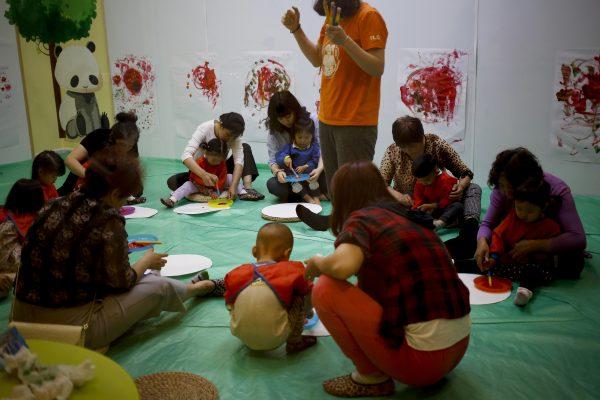 Children accompanied by their parents and caretakers attend an art class at the I Love Gym center in Beijing, China, on May 11, 2016. (AP Photo/Andy Wong)