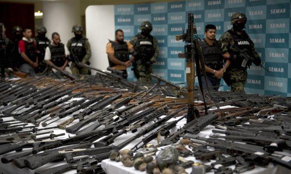 Mexican marines escort five alleged Zeta drug cartel traffickers in front of seized items—RPG-7 rocket launcher, hand grenades, firearms, cocaine, and military uniforms—presented to the press on June 9, 2011. (Yuri Cortez/AFP/Getty Images)