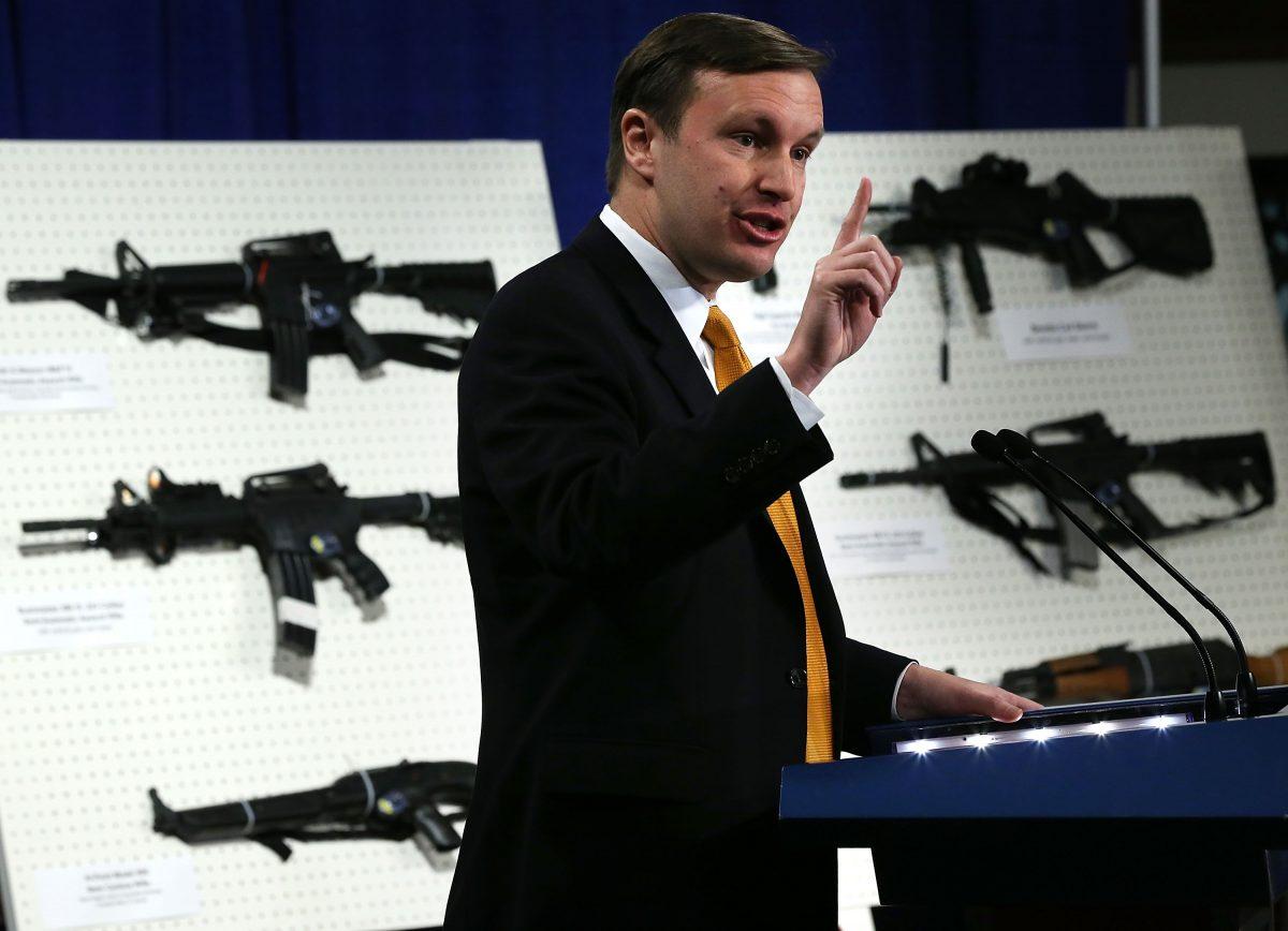 Sen. Chris Murphy (D-Conn.) speaks next to a display of assault weapons during a news conference in Washington in 2013. (Alex Wong/Getty Images)
