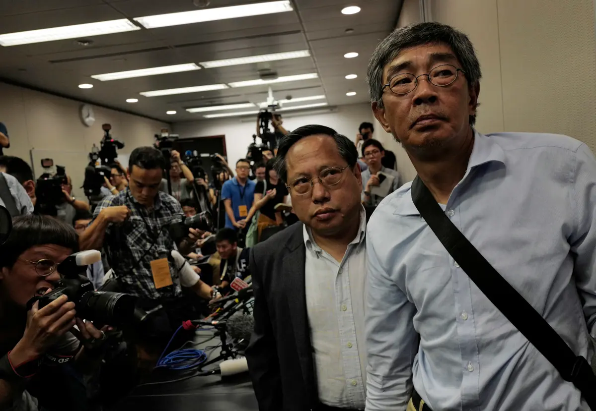 Freed Hong Kong bookseller Lam Wing-kee (R) is accompanied by pro-democracy lawyer Albert Ho after giving a news conference in Hong Kong on June 16, 2016. (AP Photo/Vincent Yu)