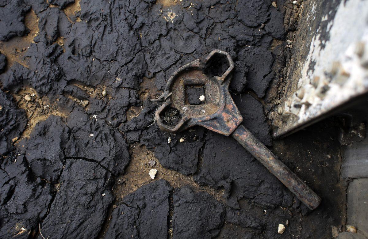 Defunct companies in the past often abandoned oil and natural gas wells that stopped producing, such as this one near Bigfoot, Texas, where an old wrench rests on oil sludge. (Eric Gay/AP Photo)