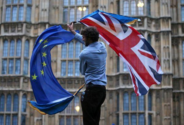 A man waves both a Union flag and a European flag outside the Houses of Parliament at an anti-Brexit protest in central London on June 28, 2016. (Justin Tallis/AFP/Getty Images)