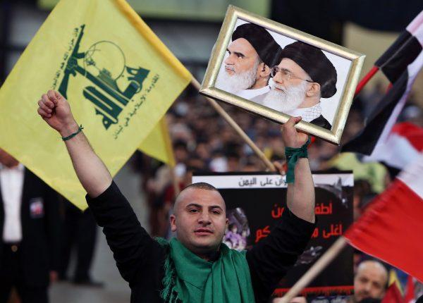 A Hezbollah supporter chants slogans, as he holds a picture of the late Iran revolutionary founder Ayatollah Khomeini (L) and Iran's Supreme Leader Ayatollah Ali Khamenei (R) during a Hezbollah-organized rally in Beirut, Lebanon, Fri., April 17, 2015. (Bilal Hussein/AP Photo)