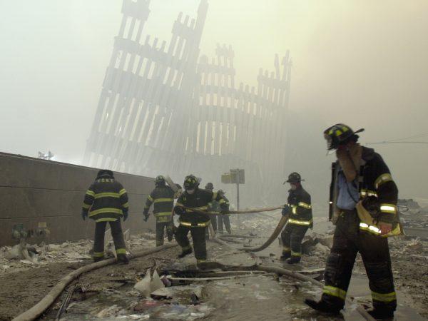 Firefighters work beneath the destroyed mullions, the vertical struts which once faced the soaring outer walls of the World Trade Center towers, after a terrorist attack on the twin towers in New York on Sept. 11, 2001. (Mark Lennihan/FILE PHOTO via AP)