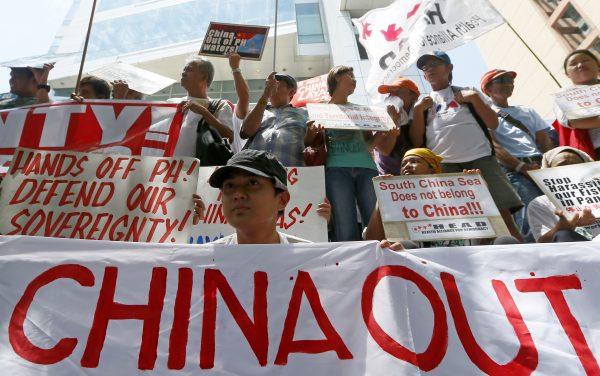 Protesters display their message during a rally outside of the Chinese Consulate hours before the Hague-based U.N. international arbitration tribunal is to announce its ruling on the South China Sea, in Makati, Philippines, located east of Manila, on July 12, 2016. (Bullit Marquez/AP Photo)