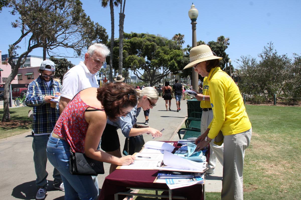 Falun Gong practitioners raise awareness about organ harvesting and other human rights crimes in China, with residents and tourists in Santa Monica, Calif., on July 17, 2016. (Xu Touhui/Epoch Times)