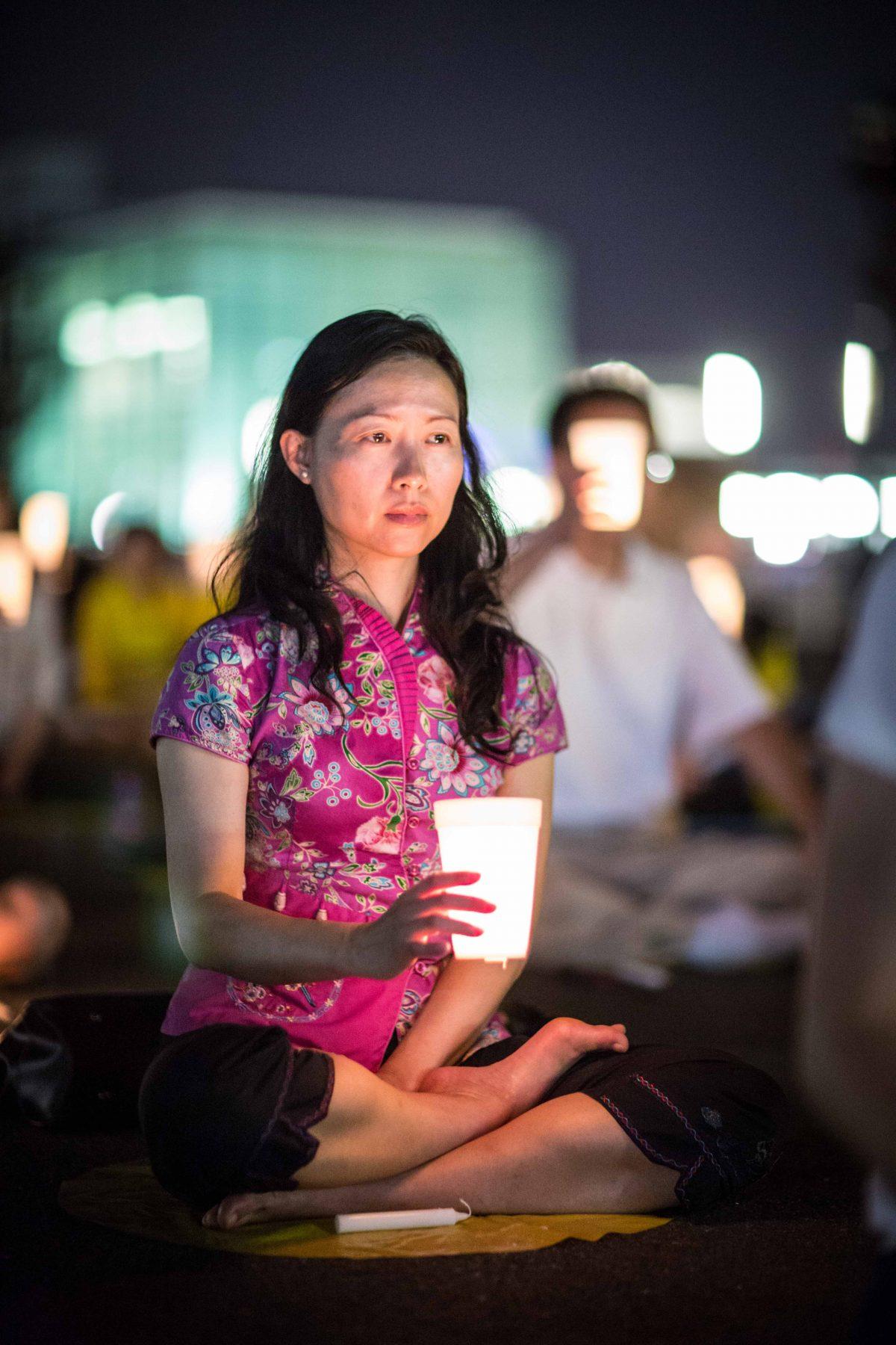 Crystal Chen, a Falun Gong practitioner, takes part in a candlelight vigil in front of the Chinese Consulate in New York on July 20, 2016. (The Epoch Times)