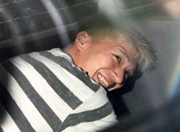 Satoshi Uematsu, the suspect of Tuesday's knife attack at a home for the mentally disabled, sits inside a police van as he leaves a police station in Sagamihara, outside Tokyo to be sent to prosecutors on July 27, 2016. (Naohiko Hatta/Kyodo News via AP)