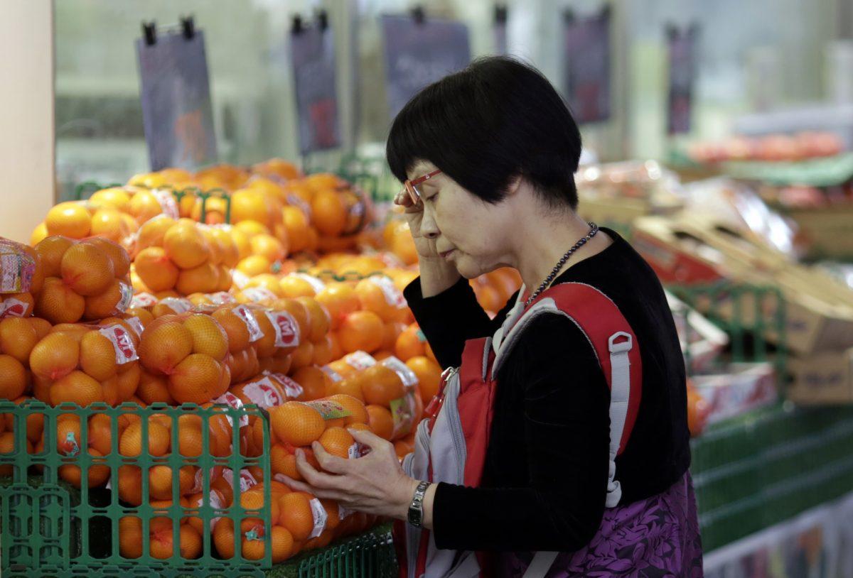 A woman takes a look at oranges on sale at a shop in Tokyo on Nov. 17, 2015. (Eugene Hoshiko/AP Photo)