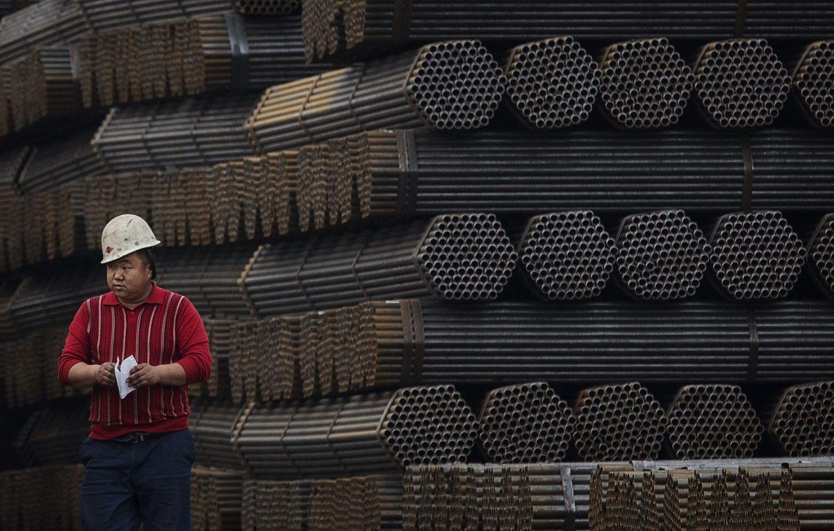 A Chinese steel worker walks past steel rods at a plant in Tangshan, China's Hebei Province, on April 6, 2016. (Kevin Frayer/Getty Images)