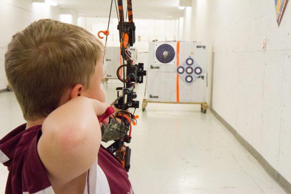 An 8-year-old Town of Wallkill resident shoots at a target from 10 yards away during archery practice at Gander Mountain in the Town of Wallkill, N.Y., on Aug. 19, 2016. (Holly Kellum/The Epoch Times)