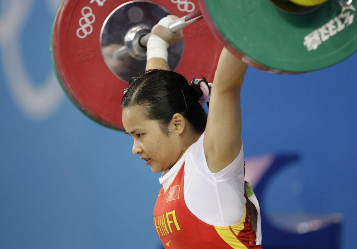 In this Aug. 9, 2008, file photo, China's Chen Xiexia holds up 90kg in the snatch of the women's 48kg weightlifting competition at the 2008 Olympics in Beijing, China. In 2017, she and other athletes from that Olympiad tested positive for banned substances and were stripped of their medals. (AP Photo/Andres Leighton)