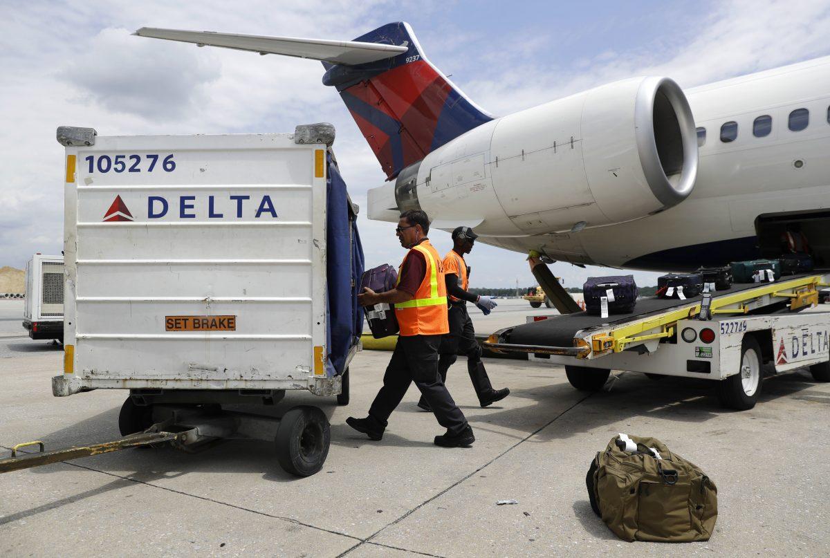Workers unload baggage from a Delta Air Lines flight at Baltimore-Washington International Thurgood Marshall Airport in Linthicum, Md., on July 12, 2016. (Patrick Semansky/AP Photo)