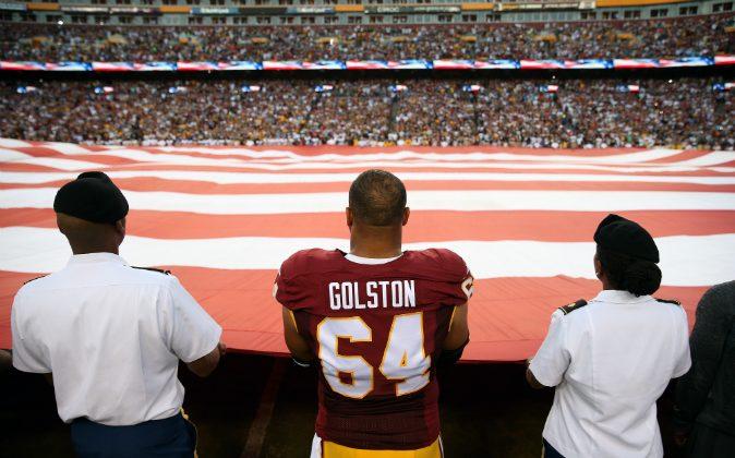Redskins Players Join Armed Forces Members in Holding Flag During National Anthem
