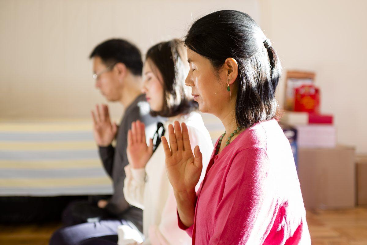 Wang Huijuan, along with her daughter and husband demonstrate their meditation practice at their home in Queens, New York, on Jan. 8, 2016. (Samira Bouaou/Epoch Times)