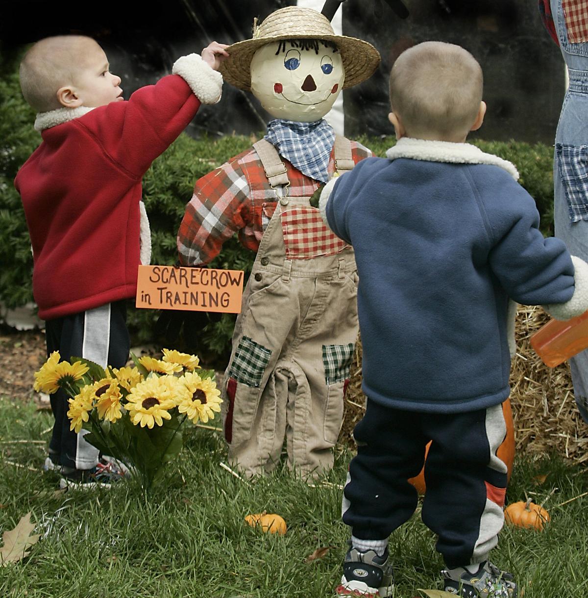 Twin brothers look over the "scarecrow in training" at the Scarecrow Festival in St. Charles, Ill., in this file photo. (JEFF HAYNES/AFP via Getty Images)