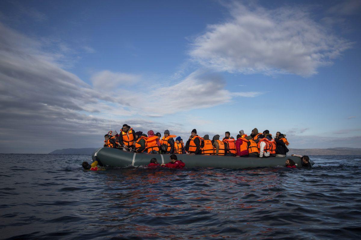 Refugees and migrants arrive on an inflatable vessel from the Turkish coast to the northeastern Greek island of Lesbos on Dec. 3, 2015. (AP Photo/Santi Palacios)
