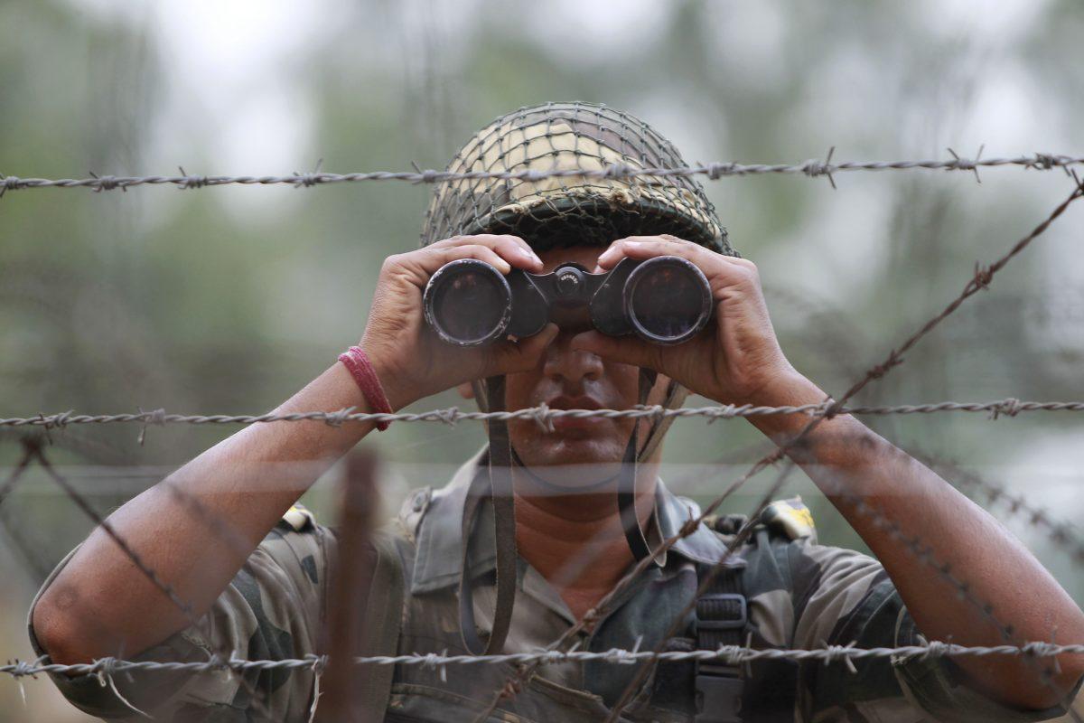An Indian Border Security Force soldier looks at the Pakistan side of the border through a binocular at Ranbir Singh Pura, about 35 kilometers (22 miles) from Jammu, India, on Sept. 24, 2016. (AP Photo/Channi Anand)