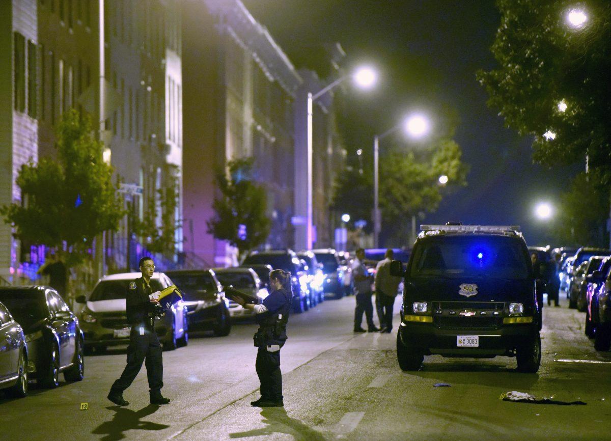 Baltimore police work at a scene where multiple people were shot in Baltimore in a file photograph. (AP Photo/Steve Ruark)