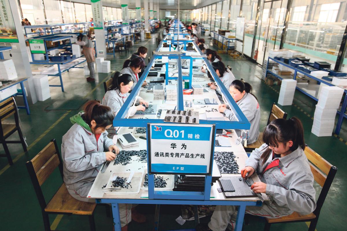 Workers sort parts at an electronics company in Tengzhou, in China’s eastern Shandong province, on Feb 1, 2016. (STR/AFP/Getty Images)