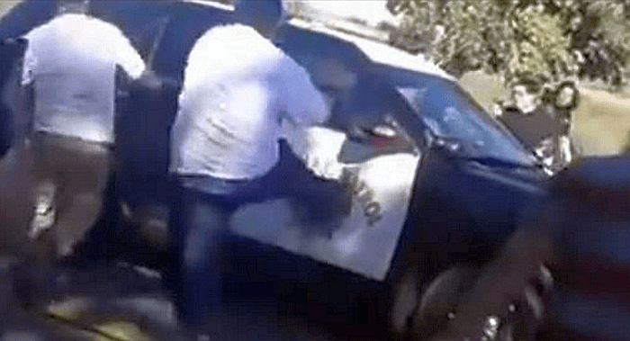 Video Shows Crowd of People Attacking California Police Officer’s Car