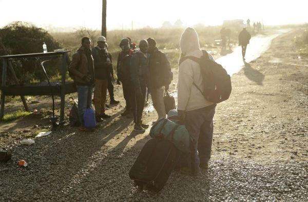 Migrants walk round the outskirts of the makeshift migrant camp known as "the jungle" near Calais, northern France, on Oct. 27, 2016. (AP Photo/Matt Dunham)