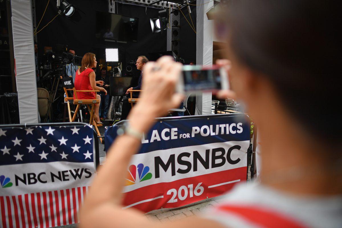 A person photographs an MSNBC news broadcast during the first day of the Republican National Convention in Cleveland, Ohio, on July 18, 2016. (Jeff J Mitchell/Getty Images)
