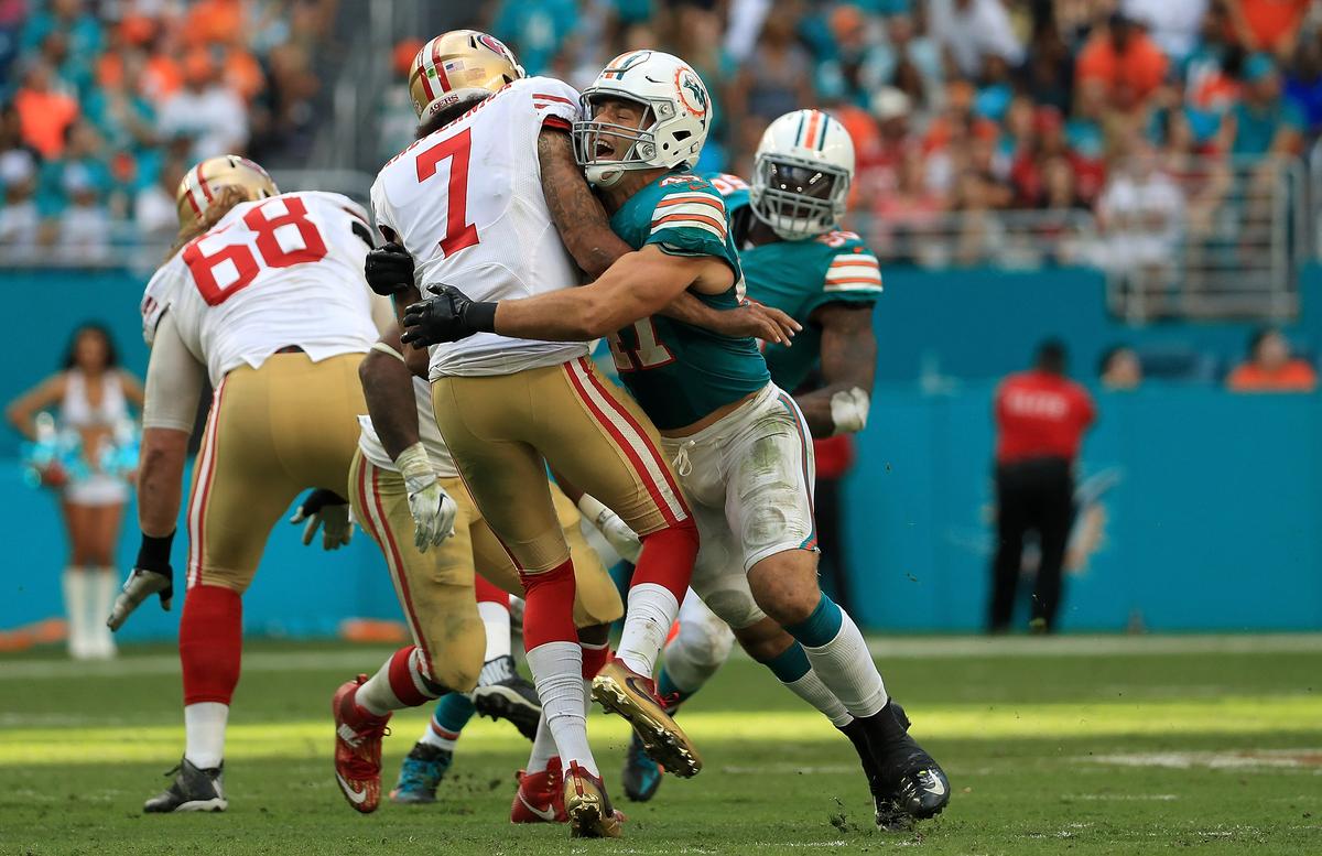 Kiko Alonso #47 of the Miami Dolphins hits Colin Kaepernick #7 of the San Francisco 49ers after a pass during a game in Miami Gardens, Fla., on Nov. 27, 2016. (Mike Ehrmann/Getty Images)