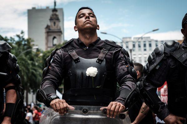 A riot police officer bearing a white flower on his bulletproof vest takes part in a public servants' protest against austerity measures in front of the Rio de Janeiro state Assembly (ALERJ) in Brazil, on Dec. 12, 2016. (Yasuyoshi Chiba/AFP/Getty Images)