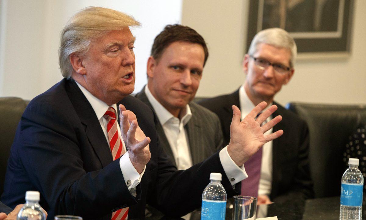 Apple CEO Tim Cook (R) and PayPal founder Peter Thiel (C) listen as President-elect Donald Trump speaks during a meeting with technology industry leaders at Trump Tower in New York on Dec. 14, 2016. (Evan Vucci/AP Photo)