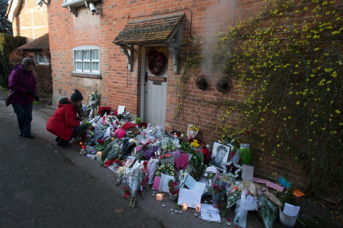 People look at the tributes outside the home of British singer George Michael in the village of Goring, England, where the singer died of apparent heart failure on Christmas Day on Dec. 27, 2016. (Daniel Leal-Olivas/AFP/Getty Images)