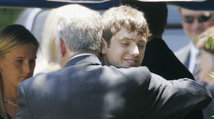 In this June 29, 2006, file photo, John Ramsey hugs his son, Burke (facing camera) at the graves of his wife, Patsy, and daughter, JonBenet, during services for his wife at the St. James Episcopal Cemetery in Marietta, Georgia. Burke Ramsey sued CBS and others for $750 million over a series that aired in September 2016 that Ramsey alleges concluded he killed his sister. (AP Photo/Ric Feld, File)