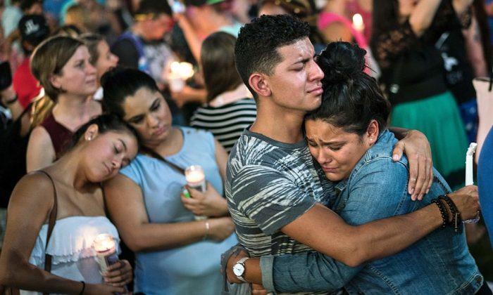 People embrace during a vigil outside the Dr. Phillips Center for the Performing Arts in Orlando, Fla., on June 13, 2016, to remember the victims of a mass shooting at the Pulse gay nightclub on the previous day. (Brendan Smialowski/AFP/Getty Images.)