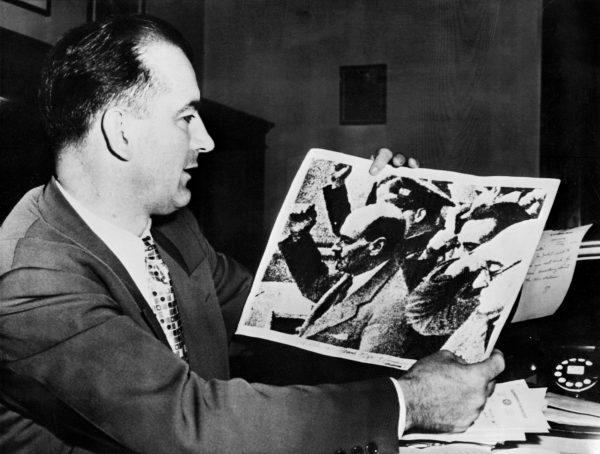 U.S. Sen. Joseph McCarthy holds a picture showing Clement Richard Attlee, British statesman and prime minister (1945–1951), making a communist salute during the Spanish civil war. (AFP/Getty Images)