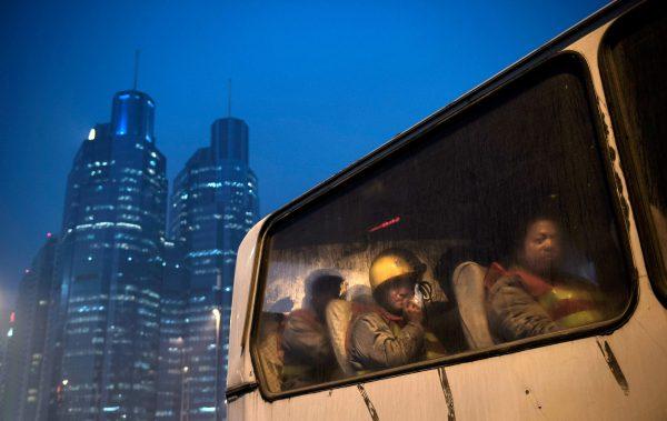 Chinese migrant workers wait in a bus as they leave after their shift at a construction site on Dec. 9, 2014 in Beijing, China. It is estimated that there are more than 40 million construction laborers in China, many of whom come from smaller centers to the country's larger cities to find work. (Kevin Frayer/Getty Images)