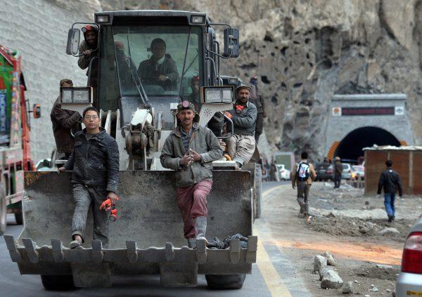 Pakistani and Chinese workers sit on an excavator as they leave the newly built tunnel in northern Pakistan's Gojal Valley, on Sept. 25, 2015. The project is part of China's ambitious One Belt, One Road initiative. (Aamir Qureshi/AFP/Getty Images)