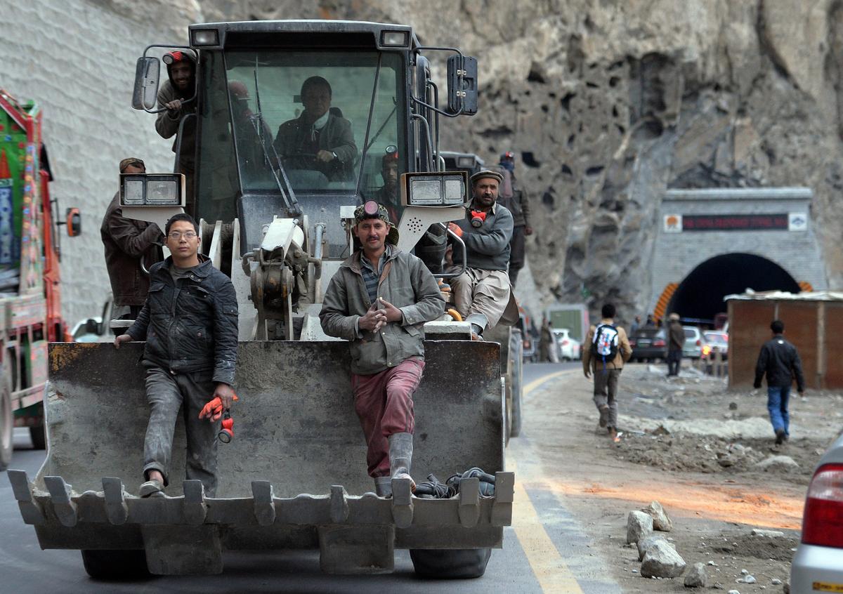 Pakistani and Chinese workers sit on an excavator as they leave the newly built tunnel in northern Pakistan's Gojal Valley, on Sept. 25, 2015. The project is part of China's ambitious Belt and Road Initiative. (Aamir Qureshi/AFP/Getty Images)